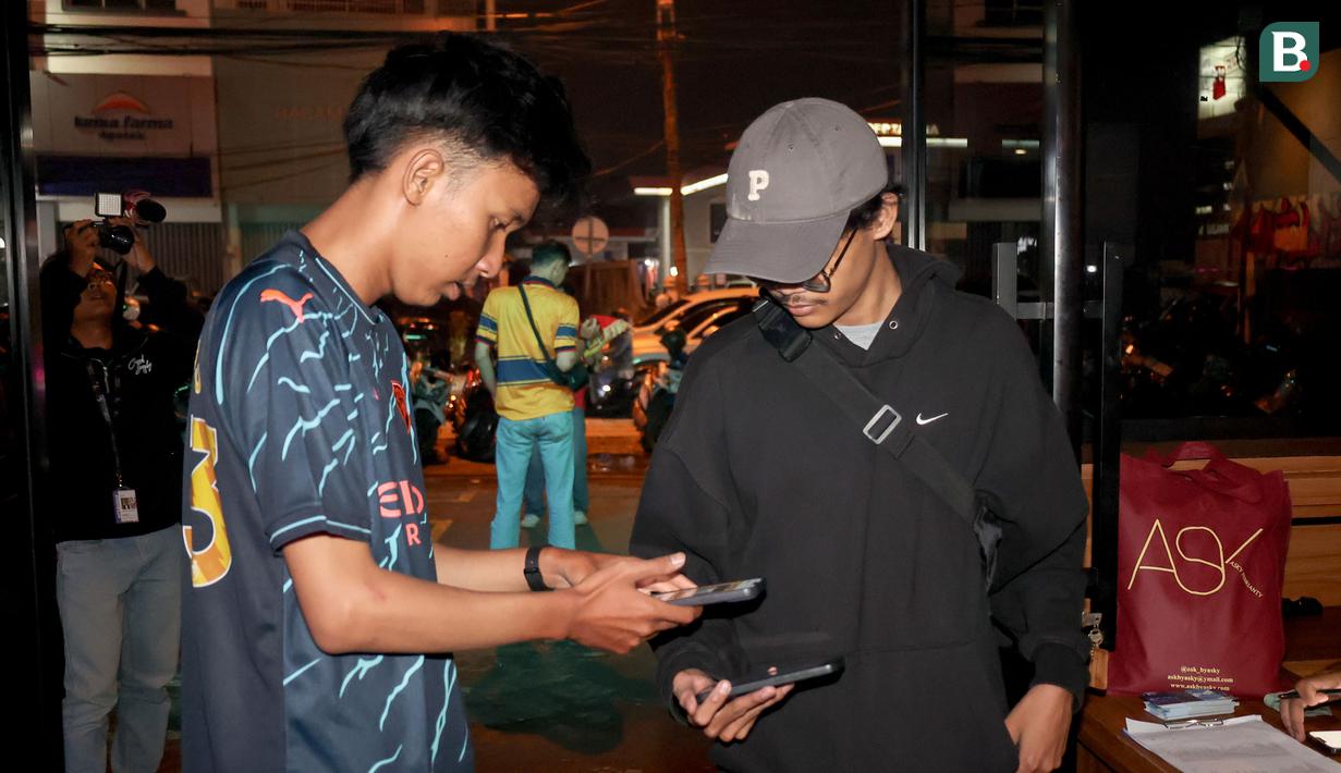 Seorang pengunjung melakukan registrasi Roaring Night Liga Inggris 2023/2024 antara Manchester City melawan Arsenal di Hype Cafe, Depok, Minggu (31/3/2024) malam. (Bola.com/Abdul Aziz)