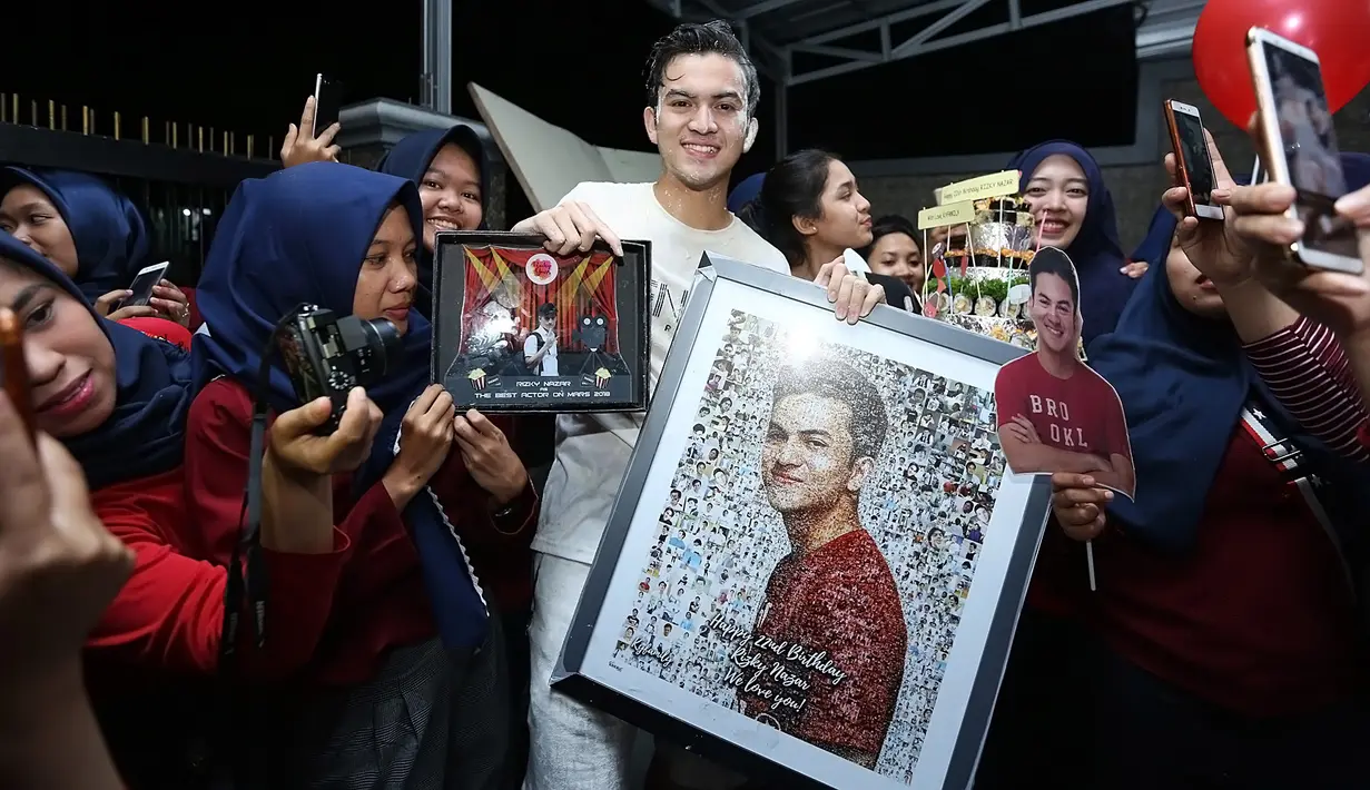 Selain kue dan balon, para penggemarnya pun membawa hadiah berupa foto Rizky Nazar. Antusias para penggemar terlihat begitu tinggi demi menyambut hari spesial sang idola.  (Bambang E.Ros/Bintang.com)