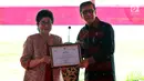 Menkes Nila F. Moeloek menyerahkan penghargaan kepada Menkumham Yasonna H. Laoly di Lapas Narkotika Kelas IIA Cipinang, Jatinegara, Jakarta Timur, Senin (17/12). (Liputan6.com/Johan Tallo)