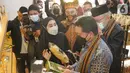 Direktur Utama Bank Syariah Indonesia (BSI) Hery Gunardi saat melihat produk UMKM usai meresmikan UMKM Centre di Banda Aceh, Rabu (29/12/2021). Kehadiran UMKM Center merupakan bagian dari upaya BSI meningkatkan kapasitas dan kapabilitas pelaku usaha di segmen tersebut. (Liputan6.com/HO/BSI)