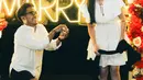 Ochi tampak mengenakan mini dress ruffle putih dengan lengan pendek dengan aksen pita pada bagian dada. Sedangkan kekasihnya mengenakan kemeja putih lengan panjang dipadukan celana pendek hitam. [@ochi24]