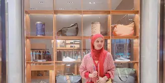 Tampil lebih berwarna, Adila mengenakan stipe cardigan sweater berwarna merah. Dipadukan dengan kerudung berwarna senada dan sling bag berwarna kuning. [instagram/dhila_bekti]