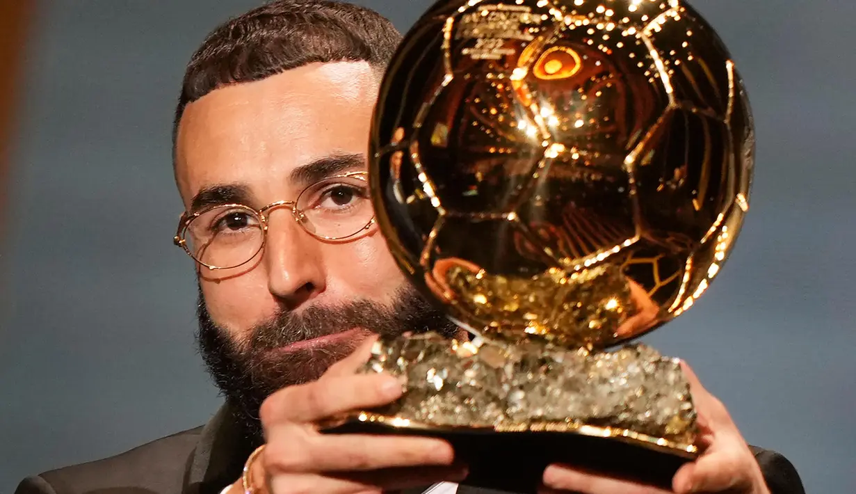 Pemain Real Madrid, Karim Benzema mengangkat trofi Ballon d'Or 2022 di Theater du Chatelet, Paris, Prancis, Senin (17/10/2022). Penampilan gemilang Karim Benzema sepanjang 2021-2022 membuat pemain asal Perancis itu menduduki posisi teratas dalam ranking Ballon d'Or 2022. (AP Photo/Francois Mori)