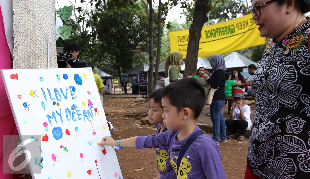 Orang tua menyaksikan anakanya melukis dalam festival laut 2015 di taman Kridaloka,  Senayan, Jakarta, Sabtu (19/9/2015). Festival bertujuan untuk mengenalkan dunia laut Indonesia kepada masyarakat serta untuk menjaganya. (Liputan6.com/Angga Yuniar)