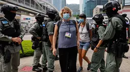 Polisi anti huru hara memeriksa kartu pers wartawan di luar gedung Dewan Legislatif di Hong Kong, Rabu (27/5/2020). Penjagaan ekstra dilakukan menimbang kemungkinan aksi menentang Rancangan Undang-undang (RUU) yang mengkriminalkan penghinaan terhadap lagu kebangsaan China. (AP Photo/Kin Cheung)