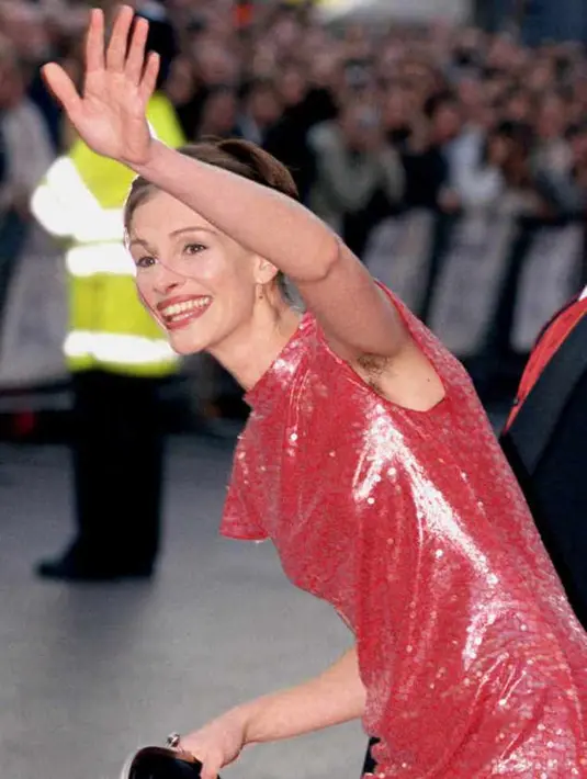 Dengan gaun merah, Julia Roberts nampak percaya diri memperlihatkan bulu ketiaknya. (Getty Image/Vogue)