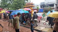 Warga yang sejak pagi tadi datang ke Wihara Dharma Bakti untuk memburu angpao Imlek tetap bertahan meski hujan, Sabtu (25/1/2020). (Liputan6.com/ Yopi Makdori)