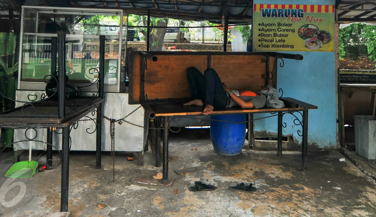 Seorang penjual makanan beristirahat di dalam warungnya, Jakarta, Selasa (7/6/2016). Selama bulan puasa, sejumlah warung makan di kawasan perkantoran memilih untuk tutup di siang hari.(Liputan6.com/Yoppy Renato)