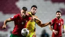 Bek timnas Portugal,  Domingos Duarte (kiri) berebut bola dengan gelandang timnas Andorra, Jordi Alaez, dalam pertandingan uji coba internasional di Estadio da Luz, Kamis (12/11/2020) dini hari WIB. Portugal menang 7-0 atas tamunya, Andorra. (PATRICIA DE MELO MOREIRA / AFP)