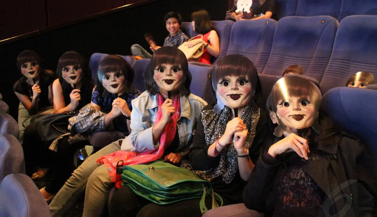 Para penonton memakai topeng boneka Annabelle yang menjadi sosok menyeramkan di film tersebut, Jakarta, (30/9/14). (Liputan6.com/Gilar Ramdhani) 