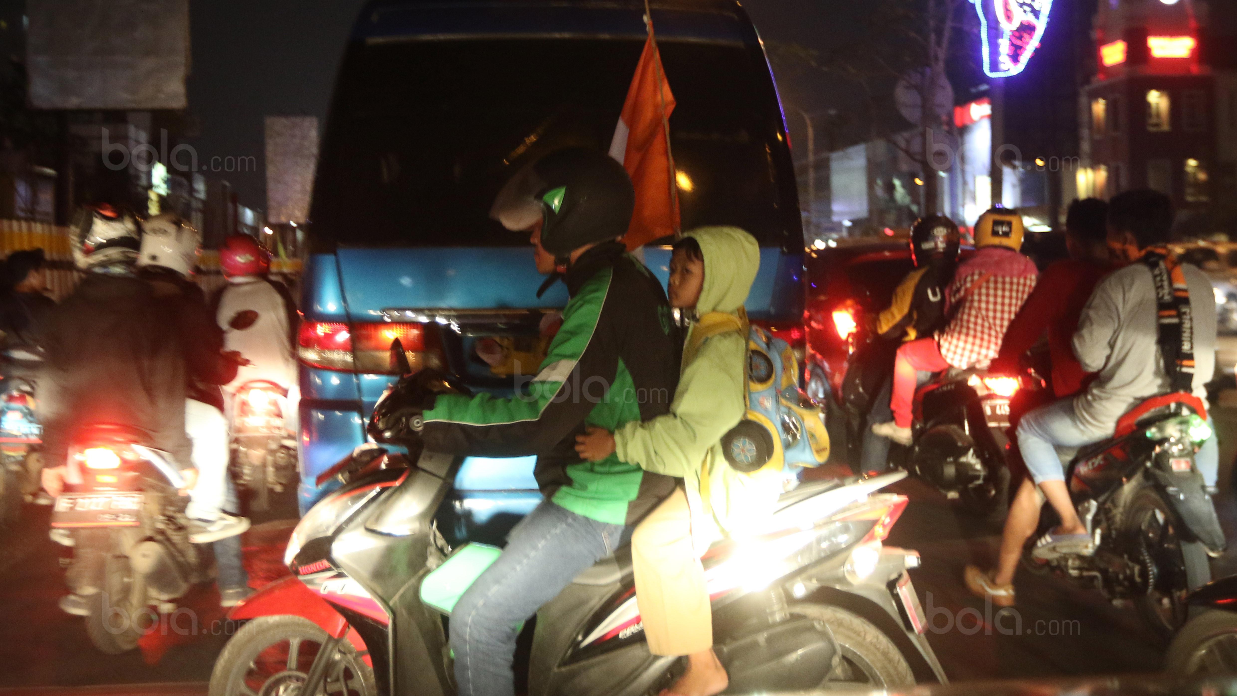 The Jakmania cilik saat pulang menggunakan ojek online. (bola.com/Nicklas Hanoatubun)