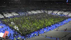 Ribuan Penonton berhamburan di lapangan stadion Stade de France saat menyaksikan pertandingan persahabatan antara Prancis melawan Jerman di Saint-Denis, Paris, (13/11). Serangan bom terjadi di dekat stadion Stade de France Prancis. (AFP PHOTO/FRANCK FIFE)