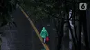Seorang pejalan kaki mengenakan jas hujan berjalan di kawasan Bundaran HI, Jakarta, Jumat (18/2/2022). BMKG mengungkapkan potensi curah hujan meningkat dan cuaca ekstrem sepanjang 17-23 Februari 2022. Sejumlah wilayah diminta waspada dampak yang terjadi dari cuaca buruk. (Liputan6.com/Faizal Fanani)