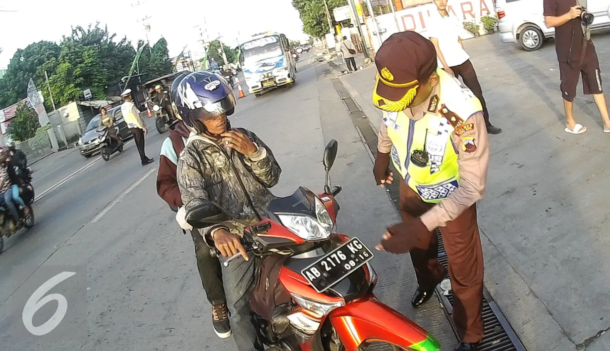 Petugas Kepolisian memberhentikan pengendara motor di Simpang Maya, Tegal, Jawa Tengah Minggu (10/7). Pemberhentian dilakukan untuk mengecek barang bawaan agar tidak membahayakan pengendara lain. (Liputan6.com/Herman Zakharia)