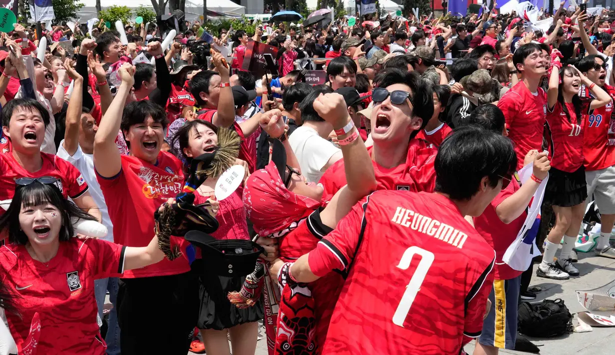 Penggemar sepak bola merayakan gol pertama yang dicetak Timnas Korea Selatan ke gawang Republik Ceko pada pertandingan sepak bola Grup A Piala Dunia 2026, di tempat penonton umum di Seoul, Korea Selatan, Jumat 12 Juni 2026. (AP Photo/Ahn Young-joon)
