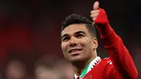 Gelandang Manchester United,Casemiro memberi isyarat kepada para pendukung selama perayaan juara Carabao Cup 2022/2023 mengalahkan Newcastle United pada laga final di Stadion Wembley di London, Senin dini hari WIB (27/2/2023). Kemenangan ini menuntun MU jadi juara EFL Cup/Carabao Cup 2022-2023. Trofi pertama di era Ten Hag. (AFP/GLYN KIRK)