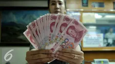 Petugas menunjukkan uang pecahan 100 Yuan di tempat penukaran uang, Jakarta, Kamis (13/8/2015). Kebijakan Tiongkok yang sengaja melemahkan (devaluasi) mata uang Yuan membuat Rupiah melemah terhadap dolar AS. (Liputan6.com/Johan Tallo)
