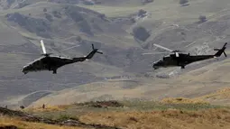Helikopter militer melintas selama komando strategis dan staf melakukan latihan Center-2019 di lapangan tembak Lyaur, Tajikistan, Rabu (18/9/2019). Prajurit Rusia, Kazakhstan, Kirgistan, Tajikistan, Uzbekistan, India, Pakistan, dan China ikut serta dalam latihan ini. (AP Photo/Grits Sergei)