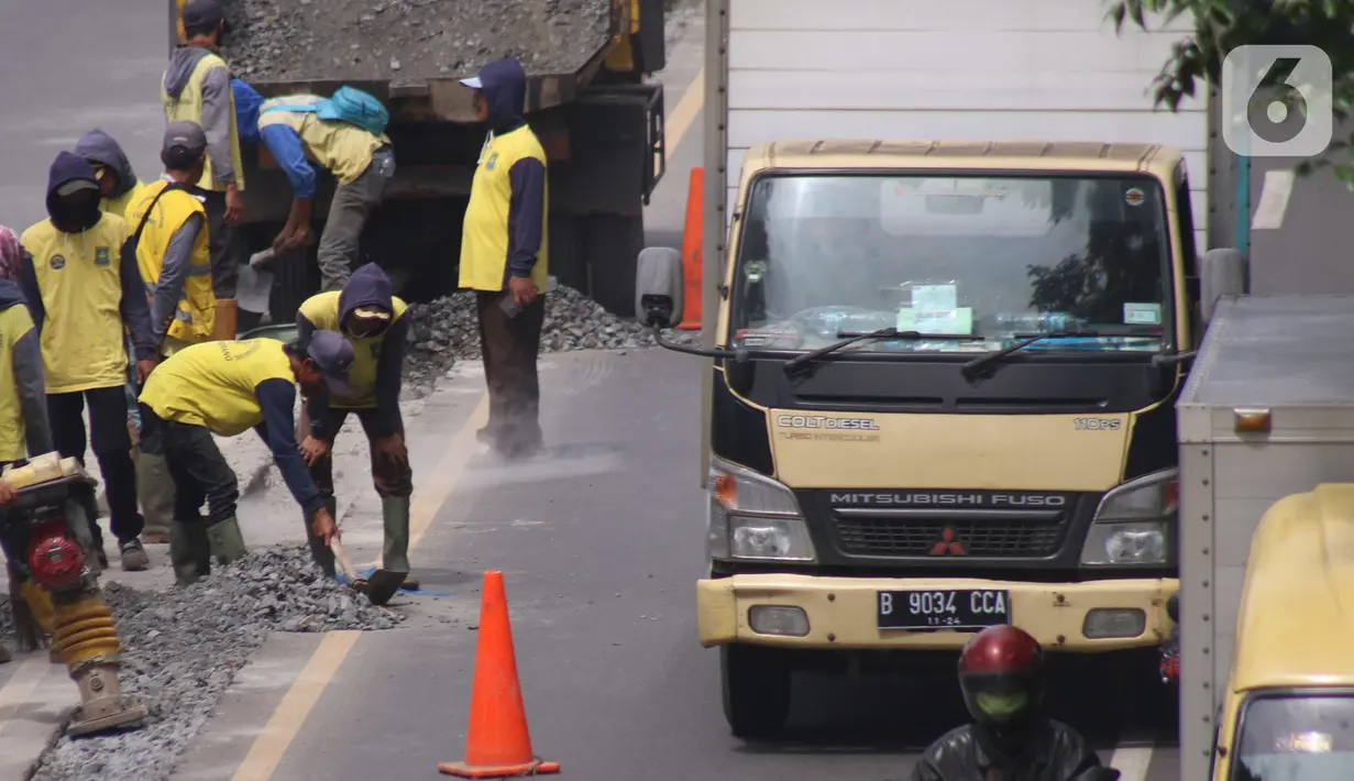 Pekerja melakukan penataan di ruas jalan nasional di Jalan Daan Mogot, Kota Tangerang, Banten, Selasa (15/2/2022). Pemkot Tangerang berencana melakukan sistem satu arah di Jalan Daan Mogot untuk mengatasi kemacetan di akses masuk tol Cengkareng-Batu Ceper-Kunciran. (Liputan6.com/Angga Yuniar)
