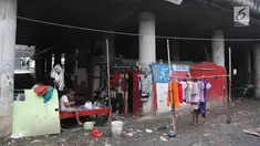 Warga beraktivitas di permukiman kolong Jalan Tol Pelabuhan, Tanjung Priok, Jakarta, Senin (23/4). Mahalnya harga hunian di Ibu Kota membuat mereka tinggal di kawasan tersebut meski dengan kondisi lingkungan kumuh dan kotor. (Liputan6.com/Arya Manggala)