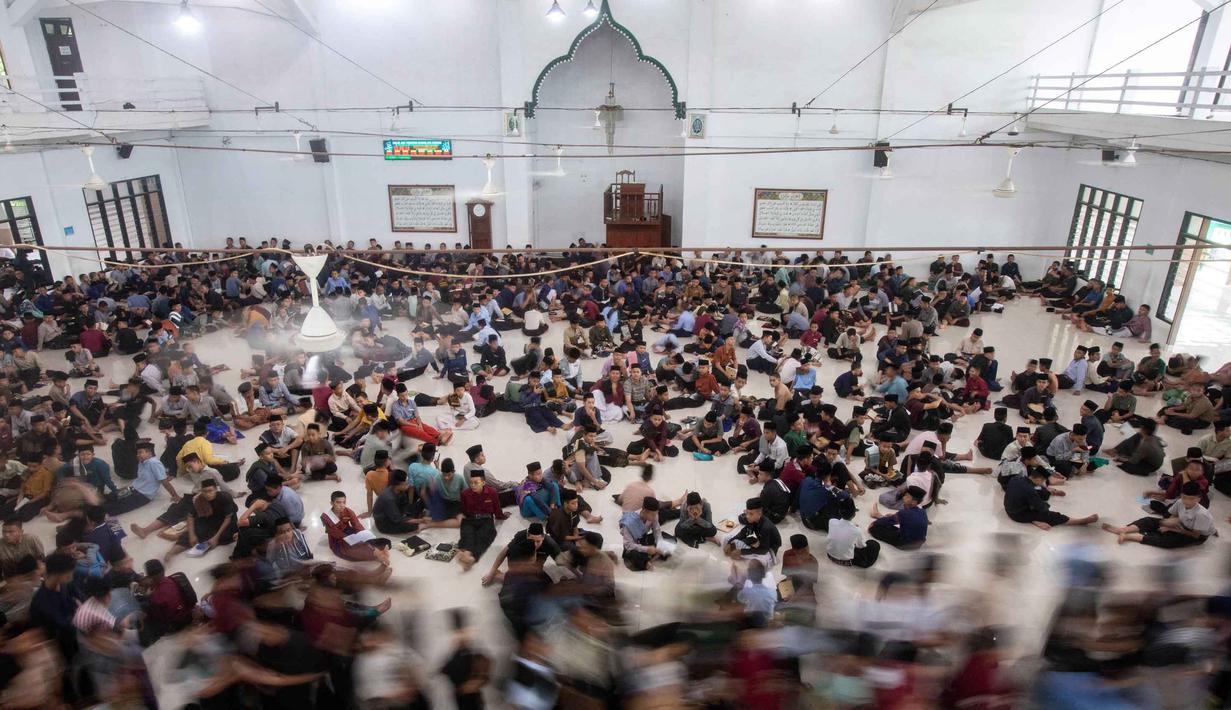 Mereka membaca Al-Quran dengan formasi melingkar yang menjadi bagian dari rutinitas selama bulan suci Ramadan. Tampak dalam foto, para siswa atau santri berjalan keluar dari masjid setelah shalat Zuhur selama bulan suci Ramadan 1447 Hijriah di Pondok Pesantren Ar-Raudlatul Hasanah di Medan, Sumatera Utara, Sabtu 21 Februari 2026. (AP Photo/Binsar Bakkara)