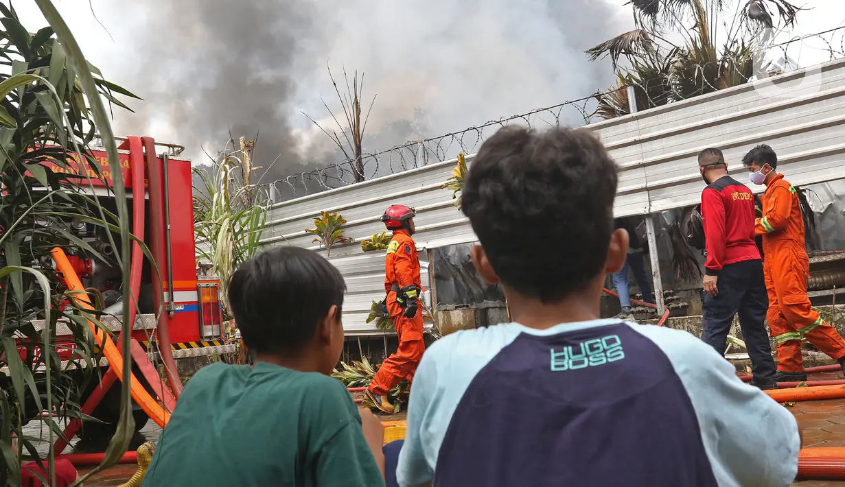 Warga melihat kebakaran yang melanda gudang alat pesta di kawasan Cinangka, Depok, Senin (2/8/2021). Sampai saat ini penyebab kebakaran hingga kerugian belum diketahui. (Liputan6.com/Herman Zakharia)