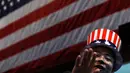 Seorang pria mengenakan topi bermotif bendera Amerika Serikat saat menonton siaran langsung pemilihan presiden AS yang digelar di Kedutaan Besar AS di Beijing, Rabu (9/11). (AP Photo / Andy Wong)