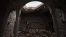 Seorang tentara Irak berjalan di puing bangunan Gereja St. George Monastery (Mar Guguis) di Mosul, 22 Januari 2017. Salah satu gereja bersejarah di Irak tersebut tak luput dari pengerusakan yang dilakukan kelompok radikal ISIS. (AHMAD AL-RUBAYE/AFP)