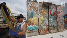  Seniman Teguh Ostenrik saat memasang bongkahan Tembok Berlin di RPTRA Kalijodo, Jakarta, Selasa (26/9). Empat segmen pecahan Tembok Berlin dan 14 "Patung Menembus Batas" untuk memperindah bekas lokalisasi Kalijodo. (Liputan6.com/Immanuel Antonius)