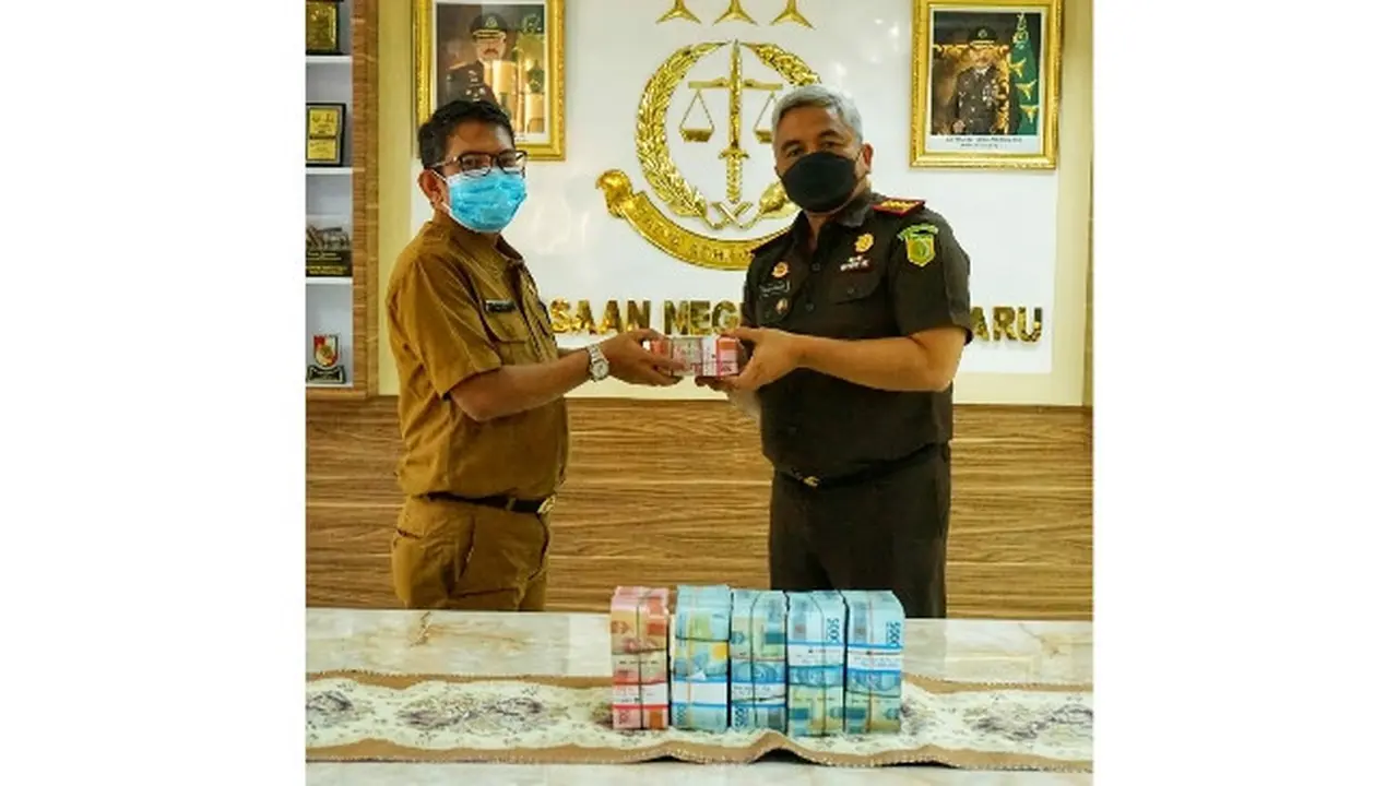Kepala Kejari Pekanbaru menyerahkan uang pengembalian negara korupsi penelitian UIR kepada kas daerah.