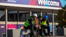 Para pekerja Mobile World Congress (MWC) 2020 duduk di luar lokasi pameran di Barcelona, Spanyol, Kamis (13/2/2020). Penyelenggara MWC 2020, GSMA, batal menggelar pameran telekomunikasi terbesar di dunia tersebut karena ancaman virus corona. (AP Photo/Emilio Morenatti)