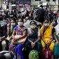 Orang India yang menunggu di stasiun kereta api memakai masker pelindung sebagai tindakan pencegahan terhadap pandemi Virus Corona. (Rajanish Kakade / AP Photo]
