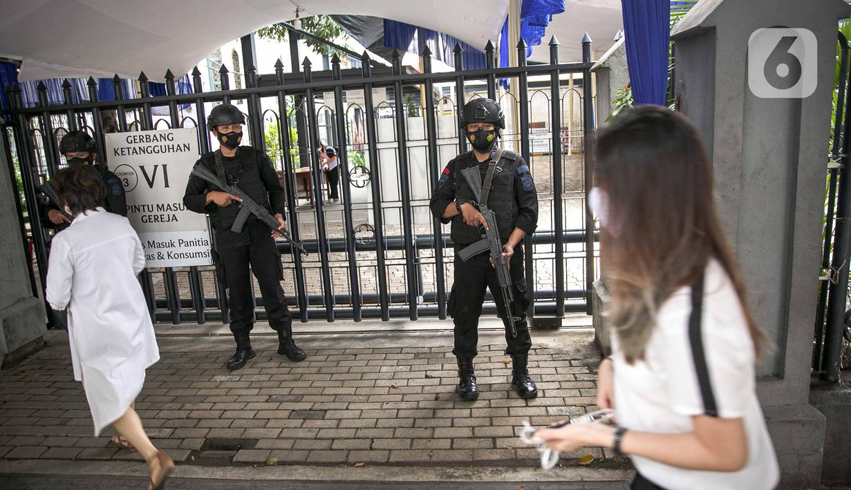 Personel kepolisian bersenjata lengkap melakukan penjagaan di gerbang masuk Gereja Katedral, Jakarta, Kamis (1/4/2021). Sebanyak 150 personel gabungan TNI, Polri dan Satpol PP melakukan pengamanan jelang rangkaian perayaan Hari Paskah di gereja tersebut. (Liputan6.com/Faizal Fanani)