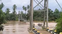 Jembatan putus di Kabupaten Kuansing karena diterjang derasnya air sungai yang meluap. (Liputan6.com/Istimewa)