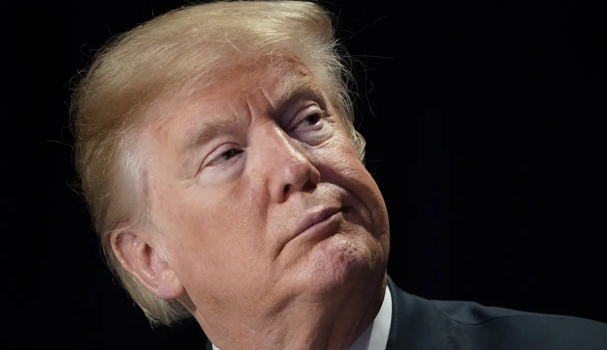 Ekspresi Presiden AS Donald Trump saat menghadiri National Prayer Breakfast di sebuah hotel di Washington DC (8/2). Dalam pidatonya Trump mengatakan bahwa iman adalah "pusat kehidupan dan kebebasan Amerika." (AFP Photo/Mandel Ngan)