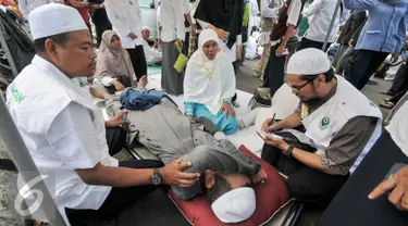 Sejumlah tim membantu demonstran yang kelelahan saat melakukan demo di depan Balai Kota, Jakarta, Jumat (4/11). Terlihat beberapa massa sedang beristirahat, dan ada juga yang sedang mendapat perawatan. (Liputan6.com/Yoppy Renato)