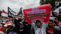 Nelayan membentangkan spanduk dalam unjuk rasa di depan Istana Negara, Jakarta Pusat, Rabu (17/1). Ada sekitar 30 ribu nelayan yang dilaporkan mengikuti aksi tersebut. (Liputan6.com/Faizal Fanani)