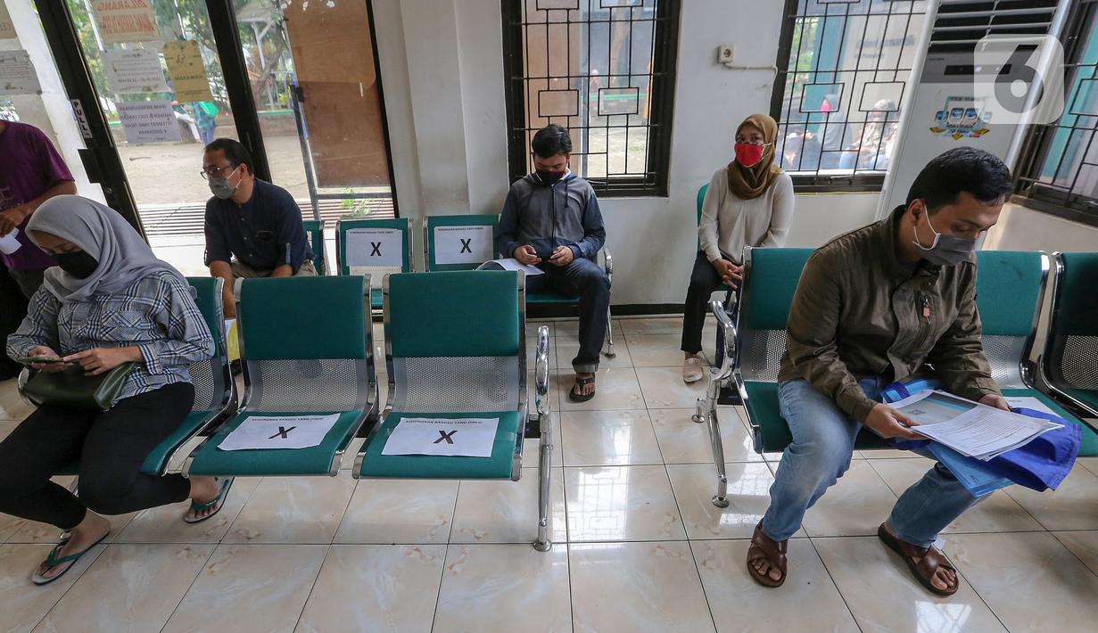 Warga duduk dengan aturan physical distancing saat antre pembuatan KTP Elektronik di Kecamatan Pamulang, Tangerang Selatan, Senin (15/6/2020). Dukcapil Tangsel membuka layanan rekaman E-KTP jelang Pilkada dengan menerapkan ketentuan New Normal. (Liputan6.com/Fery Pradolo)