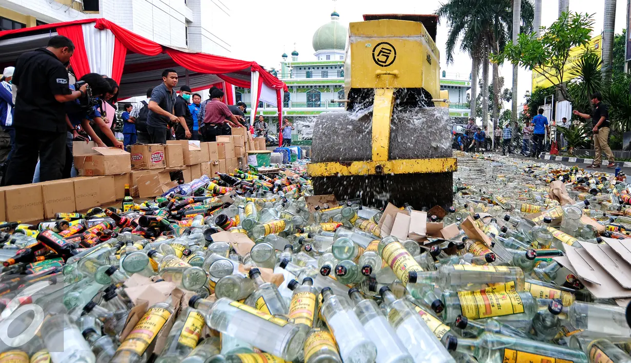 Petugas mengoperasikan Alat Berat untuk menghancurkan botol minuman keras (miras) di Mapolres Jakarta Selatan, Rabu (10/6/2015). Pemusnahan 8.000 botol miras untuk menekan peredaran miras khususnya menjelang bulan Ramadan. (Liputan6.com/Yoppy Renato)