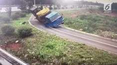 Detik-detik seorang penumpang melompat keluar dari truk. Truk yang membawa sebuah eskavator hilang kendali saat akan berbelok di tikungan.