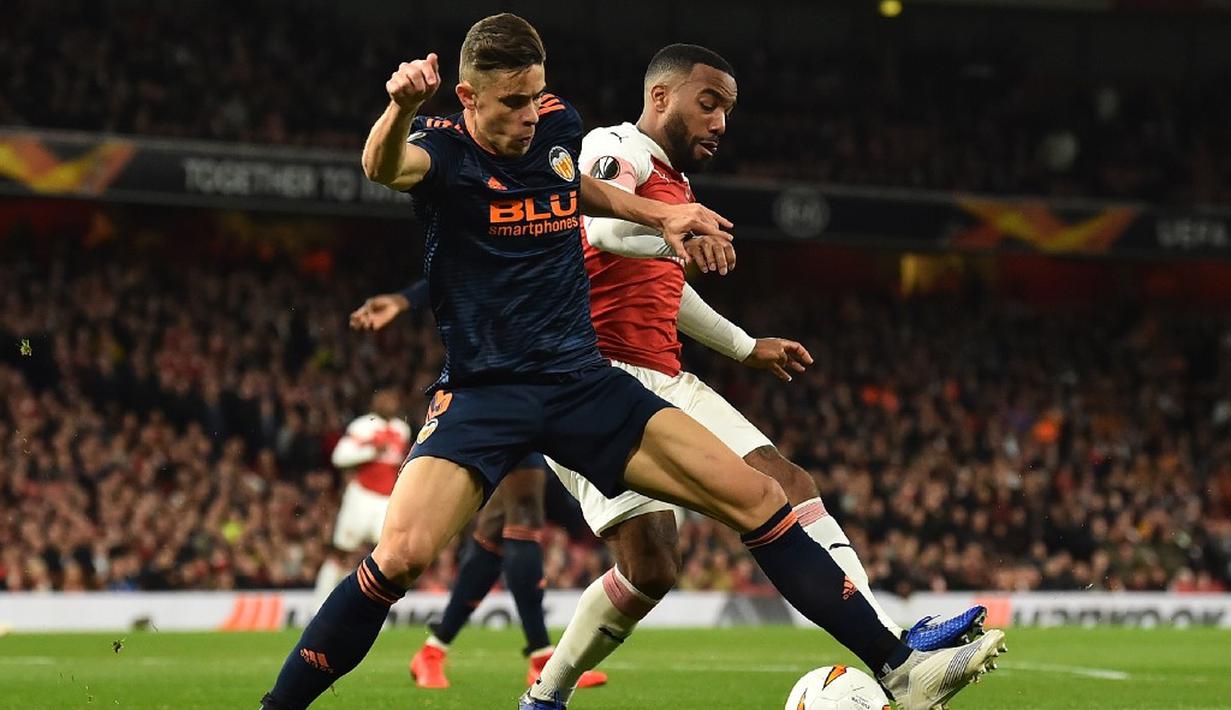 Duel antara Gabriel Paulista dan Alexandre Lacazette pada leg 1, semifinal Liga Europa yang berlangsung di Stadion Emirates, London, Jumat (3/5). Arsenal menang 3-1 atas Valencia. (AFP/Glyn Kirk)