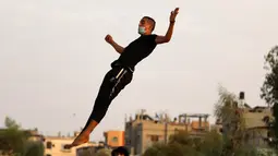 Seorang pemuda Palestina berlatih parkour selama pemberlakuan karantina wilayah (lockdown) di tengah wabah COVID-19, di Kota Khan Younis, Jalur Gaza selatan (18/9/2020). (Xinhua/Yasser Qudih)