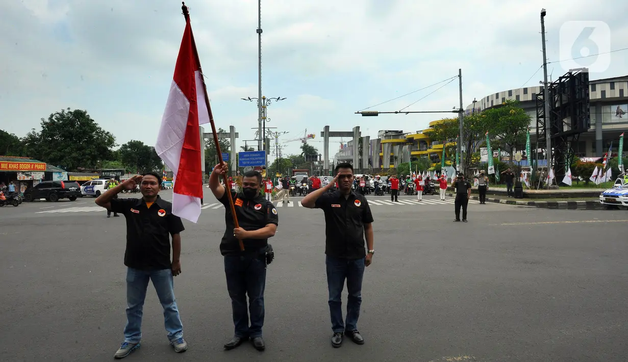 Warga bersama pengguna jalan melakukan penghormatan saat detik-detik proklamasi 17 Agustus di ruas jalan protokol Jakarta-Bogor, pertigaan Cibinong, Bogor, Jawa Barat, Rabu (17/8/2022). Sejumlah pengguna jalan terlihat turun dari kendaraannya dan melakukan sikap hormat. (merdeka.com/Arie Basuki)