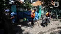 Warga dihukum dan menyapu jalan saat Razia Protokol Kesehatan di kawasan Kebayoran Lama, Jakarta, Selasa (19/10/2021). Razia PPKM Level 3 kerap dilakukan demi memutus rantai penyebaran covid 19, dengan sanksi denda Rp 100.000 dan sanksi sosial seperti menyapu jalan. (Liputan6.com/Johan Tallo)