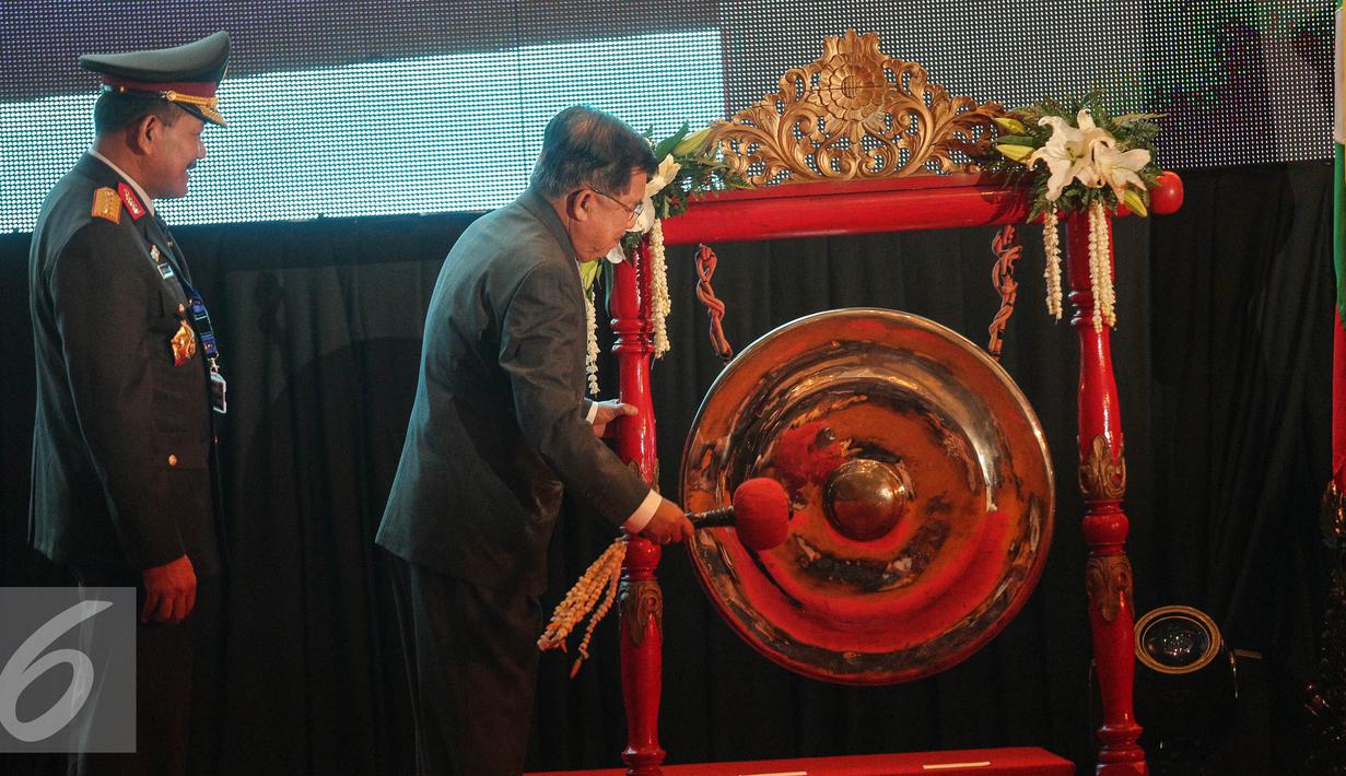 Wakil Presiden Jusuf Kalla (kanan) memukul gong tanda pembukaan Aseanapol Conference di Jakarta, Selasa (4/8/2015). Konferensi ASEANAPOl ke-35 mengusung salah satu poin kesepakatan bersama lembaga polisi se-ASEAN lainnya . (Liputan6.com/Faizal Fanani)