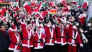 Perdana Menteri Korea Selatan Han Duck-soo (keempat dari kanan) dan para sukarelawan yang mengenakan kostum Sinterklas melemparkan topi mereka ke udara selama acara amal Natal sebelum mereka memberikan hadiah untuk orang yang kurang mampu di Seoul, Korea Selatan, 24 Desember 2022. (AP Photo/Lee Jin-man)