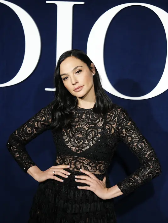 Gal Gadot berpose di depan koleksi ready-to-wear Christian Dior Fall/Winter 2023-2024 yang dipresentasikan di Paris  pada Selasa, 28 Februari 2023. Gaunnya terdiri dari atasan renda dengan garis leher tiruan yang dia lapisi di atas bralette hitam. (Vianney Le Caer/Invision/AP)