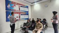 Personel Direktorat Lalu Lintas Polda Riau mengajak masyarakat yang mengurus BPKB datang ke TPS pada hari pencoblosan 14 Februari 2024. (Liputan6.com/M Syukur)