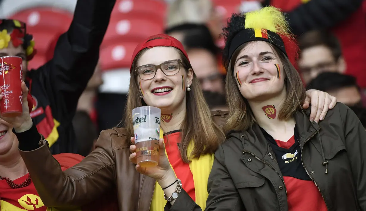 Dua Suporter cantik Belgia tengah bersiap menanti laga antara timnya melawan Wales pada perempat final Piala Eropa 2016 di Stade Pierre-Mauroy, Lille, Prancis, Sabtu (2/7/2016) dini hari WIB. (AFP/Miguel Medina)