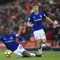 Gelandang Everton, Idrissa Gueye, terjatuh saat berusaha merebut bola dari striker Liverpool, Dominic Solanke, pada laga Premier League di Stadion Anfield, Minggu (10/12/2017). Laga bertajuk Derbi Merseyside itu berakhir imbang 1-1. (AP/Peter Byrne)